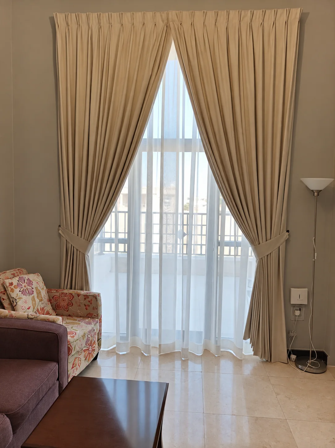 Beige drapes tied back over a sheer