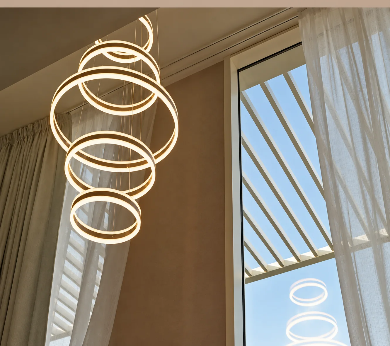 Double-height drapes under a ring chandelier