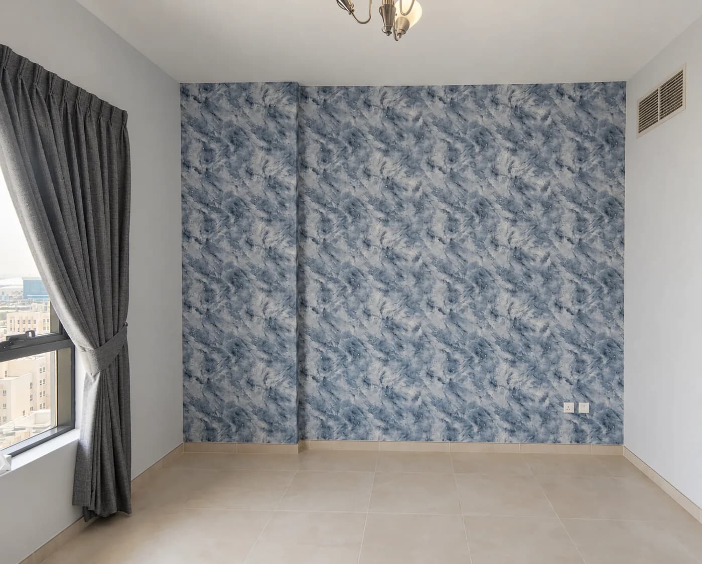A blue leaf-pattern wallpaper on a feature wall