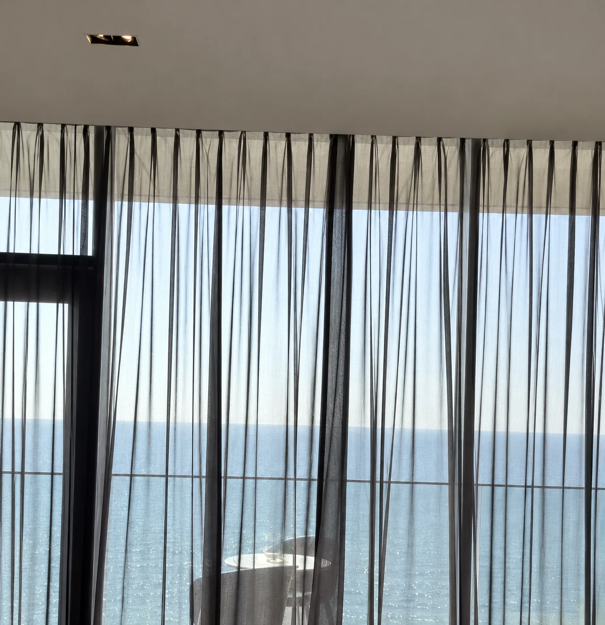 Floor-to-ceiling sheers in a sea-view apartment