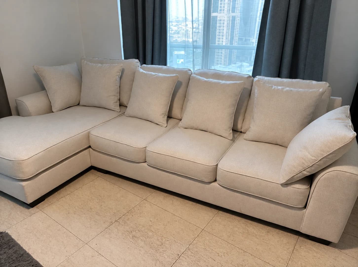 A cream L-shaped sofa with scatter cushions