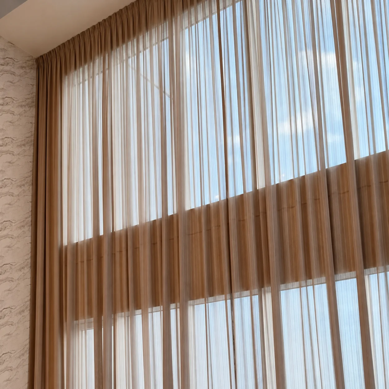 Two-tone sheers across a double-height window