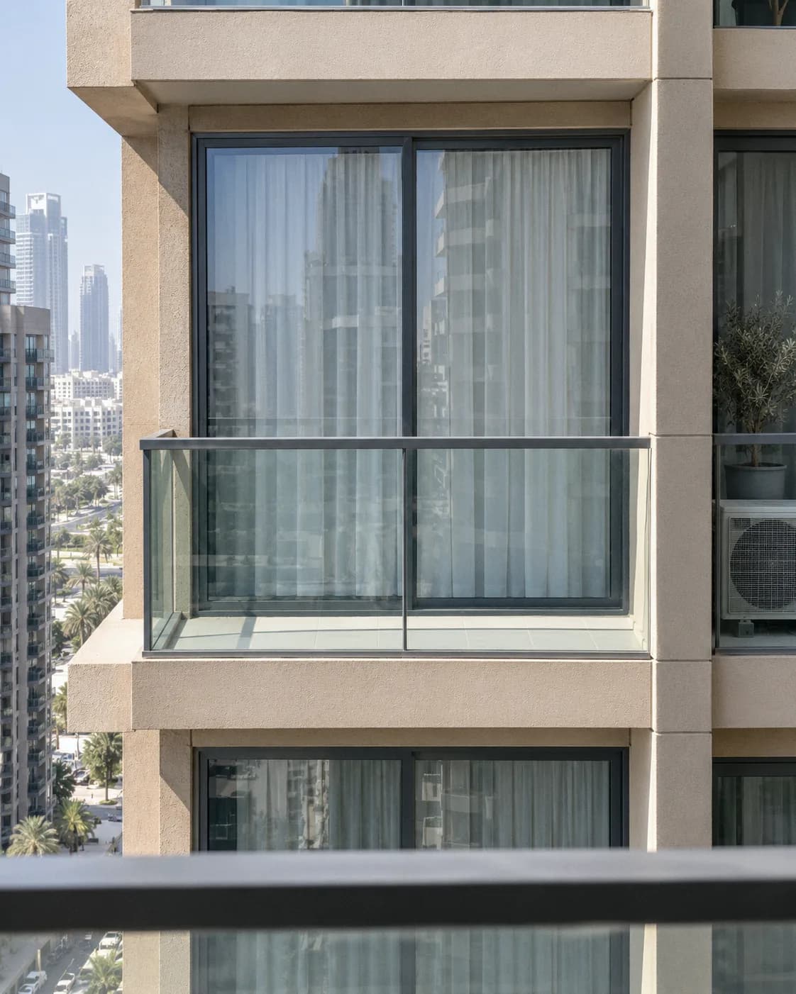 Seen from the next tower by day: a sheer drawn behind the glass looks pale and solid