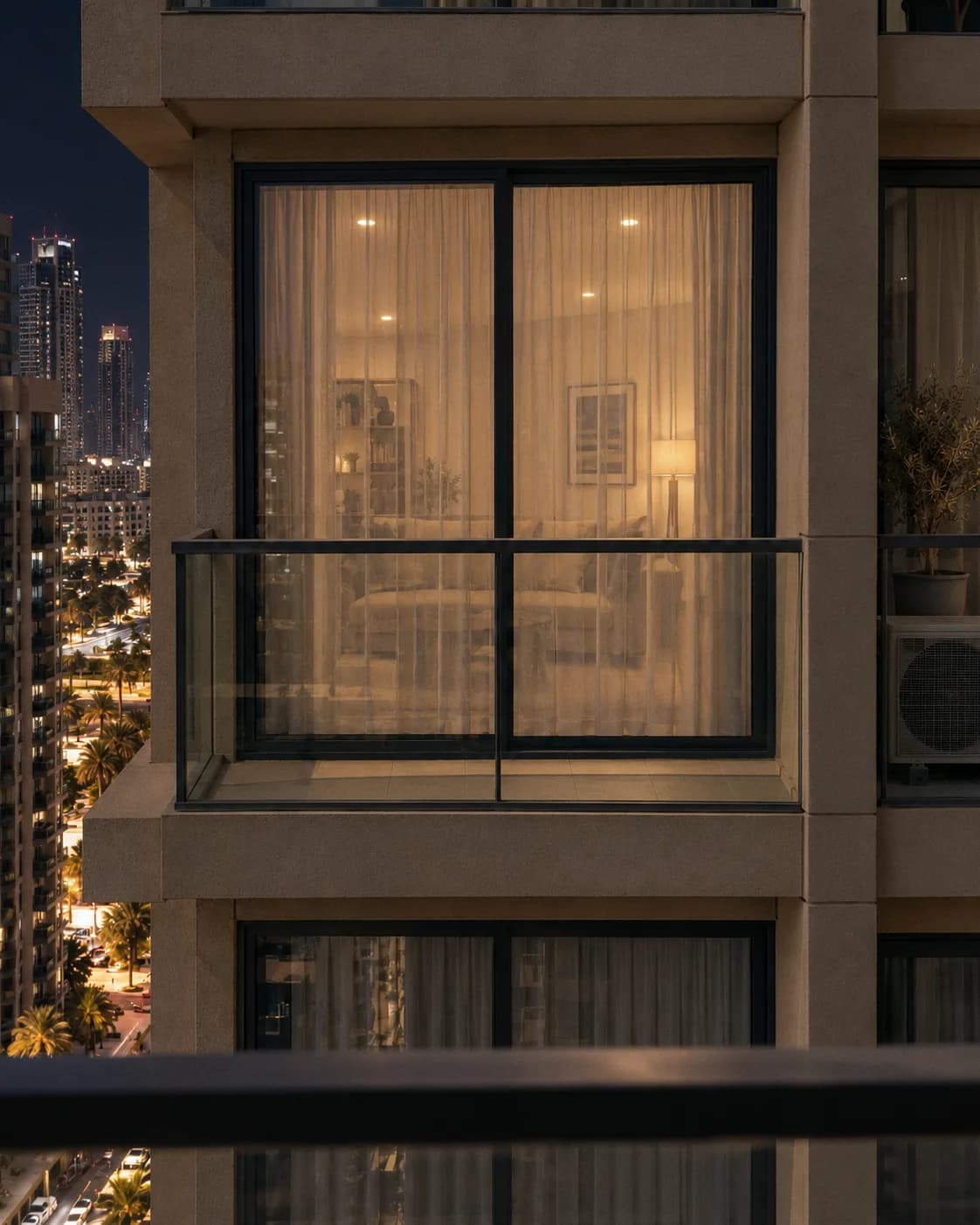 The same window at night with the room lit: the sofa and a lamp show through the sheer