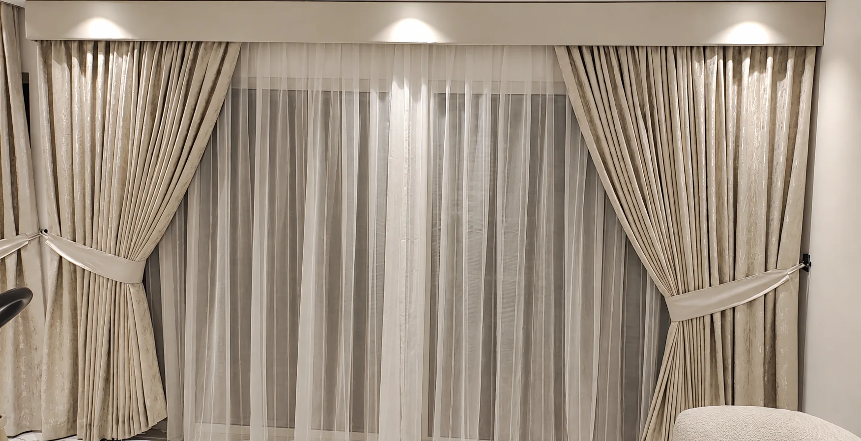 Patterned drapes with tiebacks over a sheer