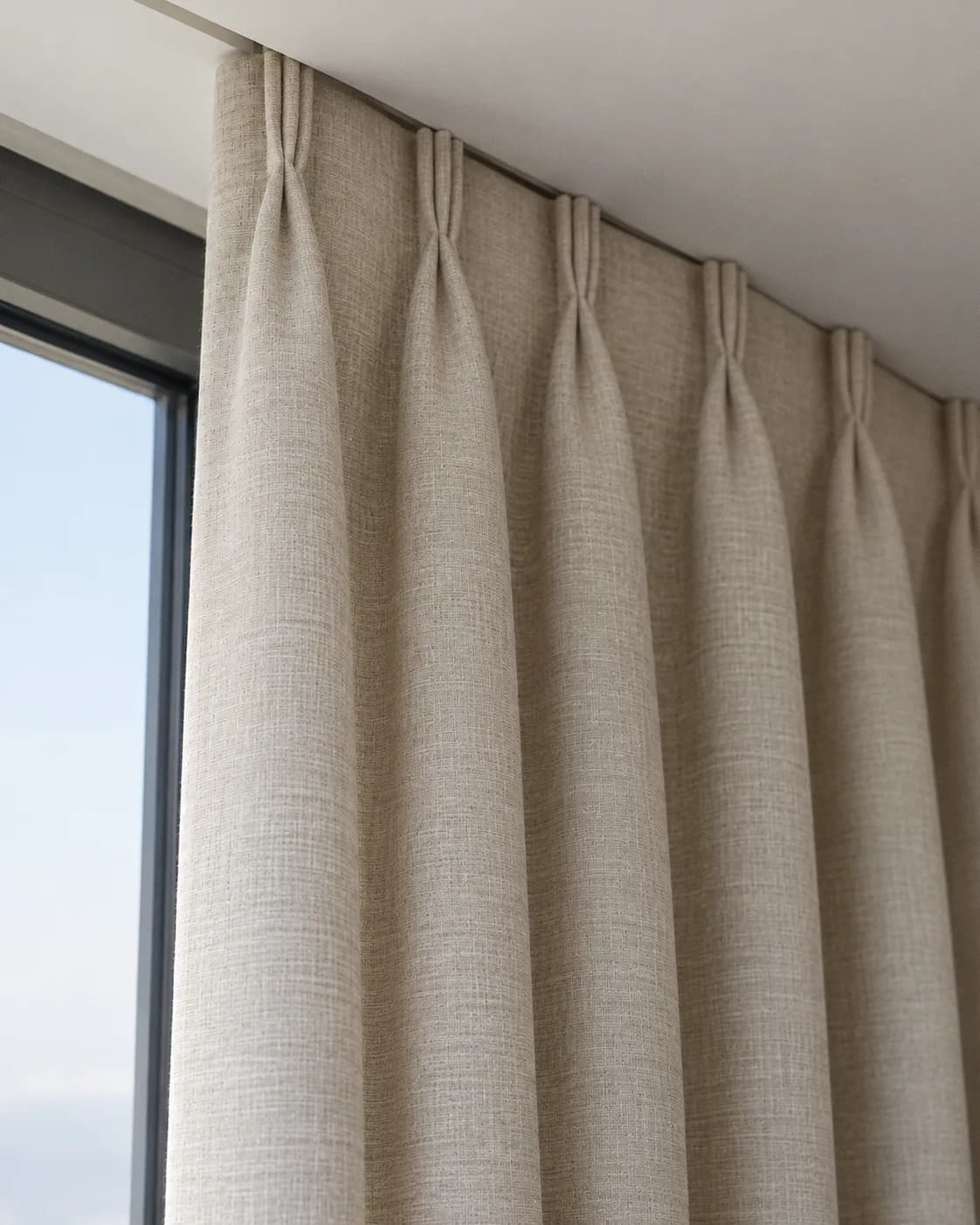 Triple pleat heading: groups of three folds stitched at the top, on the same track