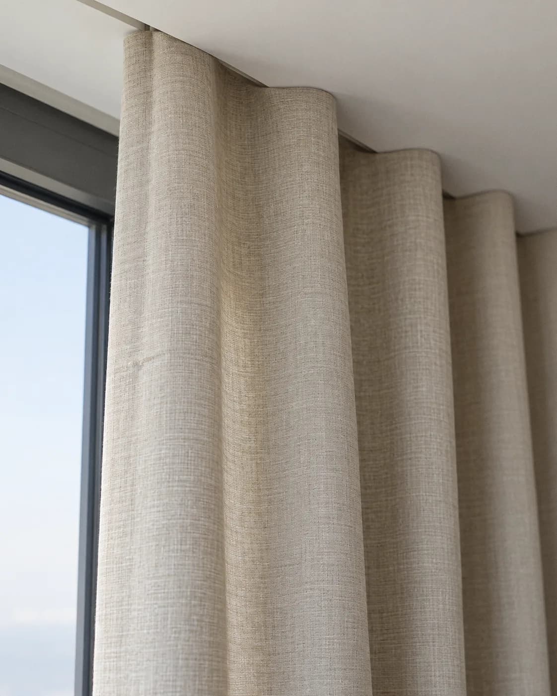 Wave heading: the fabric falls from a ceiling track in soft, even waves